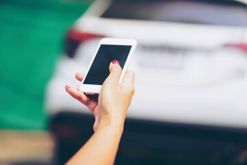 Unlocking Car Using Smartphone.New Technology for start car engine. Hand holding mobile smart phone to unlock or start car. Technology smart life concept..