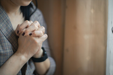 Obraz na płótnie Canvas Closeup shot of a female praying at home. christian concept.