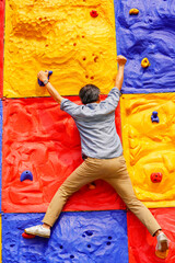 Obraz na płótnie Canvas Man climbing wall without grips. Businessman climb on colourful wall