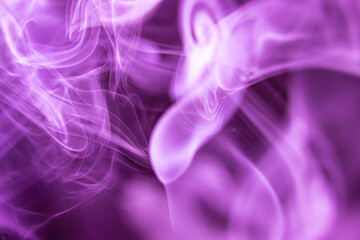 An abstract photograph of bright purple smoke on a dark background. Creative wallpaper design.