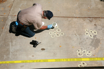 a crime scene detective investigates and gathers evidence at a drive by shooting crime scene