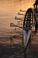 a person holding a row boat along the dock with their foot in the seattle sunrise. © mike ledray