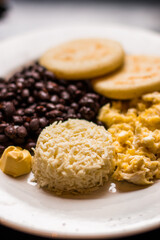 Venezuelan-type Creole breakfast with grains, scrambled egg and grated white cheese