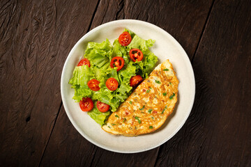 Omelet with cheese and lettuce and tomato salad.