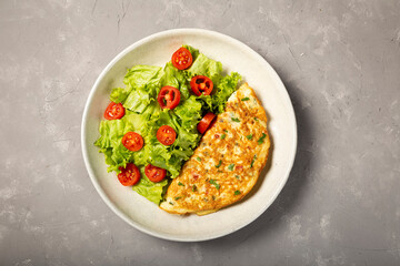 Omelet with cheese and lettuce and tomato salad.