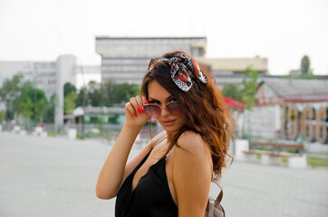 Flirty young girl, boho style holding sunglasses frame
