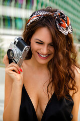 Cute girl smiling and holding analog camera 