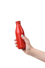 A woman's hand holds a red glass closed bottle isolated on a white background.