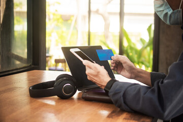Close up hand holding mobile phone shopping online with credit, Man stay at home protect coronavirus covid19