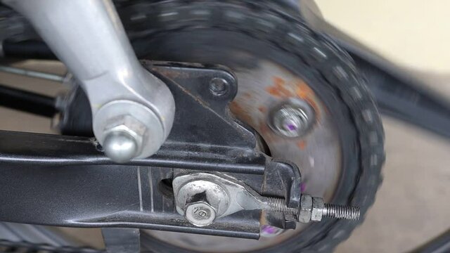 Chain and sprocket of motorcycle rear wheel is spinning with engine for testing before travelling.