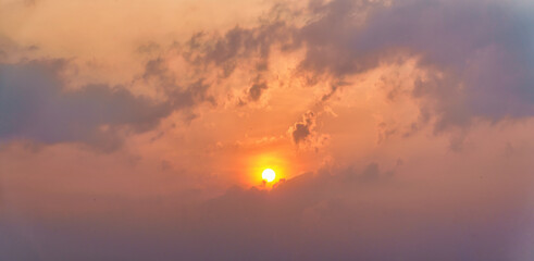 panoramic natural sky background of sun rising over gloden cloudy sky