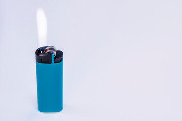 Blue gas lighter burning with fire on a light background.