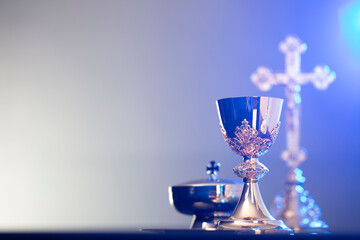 Religion theme – Easter. Catholic symbols composition. The Cross, monstrance  and golden chalice on blue background.  - obrazy, fototapety, plakaty