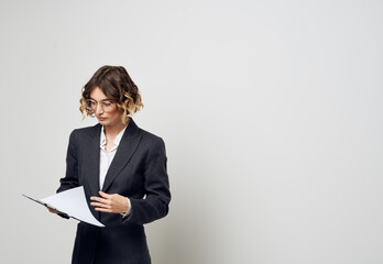 Business woman with documents in hands on a light background indoors