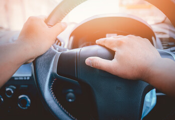 A man's hand is pressed to the horn of a car to warn vehicles that are not complying with traffic laws, which could pose a danger to his and other vehicles, as well as to the commuters
