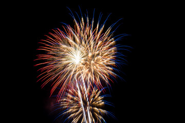 Fototapeta premium Fireworks of various colours on black background. New Year celebration colourful fireworks.