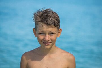 Young boy is enjoying on the beautiful tropical beach at summer, close up portrait © OlegD