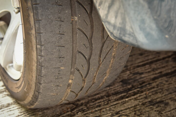 Old tire with worn tread and scratch, worn old car tire tread with damaged, scratch, worn tire tread in the car wheel