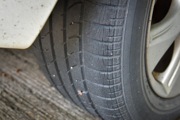 Old tire with worn tread and scratch, worn old car tire tread with damaged, scratch, worn tire tread in the car wheel