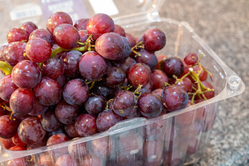 画面アップの買ってきたばかりのプラスチックのケースに入ったブドウ