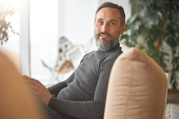 Fototapeta premium Happy adult caucasian man is working in a modern office