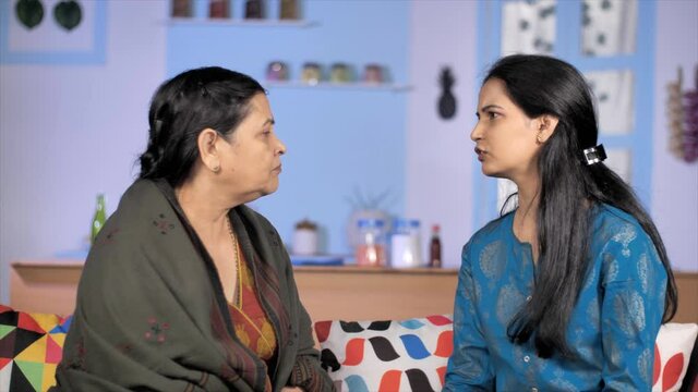 Two angry and stubborn ladies arguing - misunderstanding and disagreement. Aged Indian mother fighting / quarreling with her adult daughter-in-law at home - generations gap