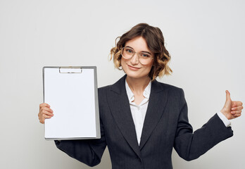 Naklejka premium Woman shows a blank sheet of paper on a light background business finance Copy Space