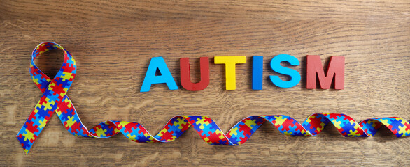 World autism awarenes day. Puzzle pattern ribbon on wooden background
