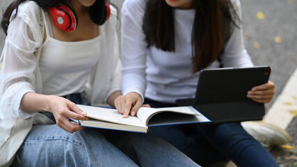 Cropped shot of two female college students using computer tablet learning and preparing for exam.