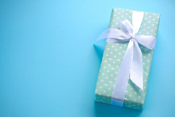 Present on blue background.women day. Mother day .Gift with white ribbon.