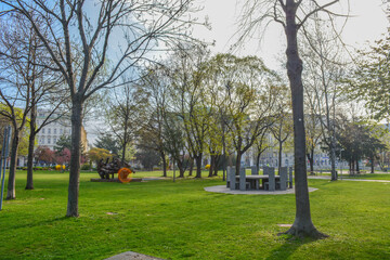 A quiet park with green lawn and lush tree