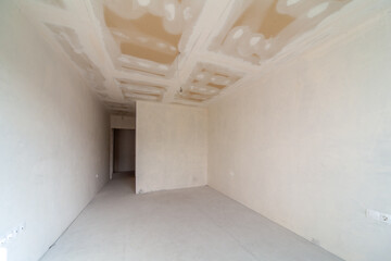 New empty room under construction. Plaster walls. New home. Concrete walls. Interior renovation.