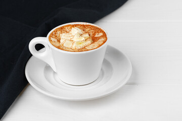 Cup of coffee with whipped cream on white table