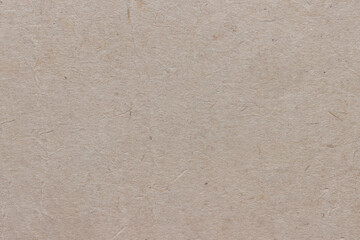 The surface of old worn brown cardboard, covered with creases and stains. Uniform light abstract texture.