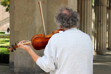 Man on his back playing violin