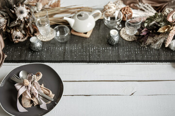 Festive table setting design with many hygge-style decor details.