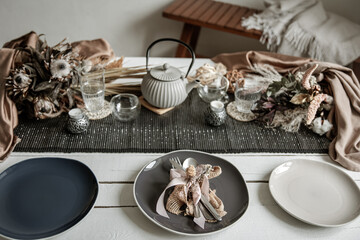 Festive table setting design with many hygge-style decor details.