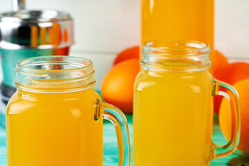 Glass with orange juice on green wooden table