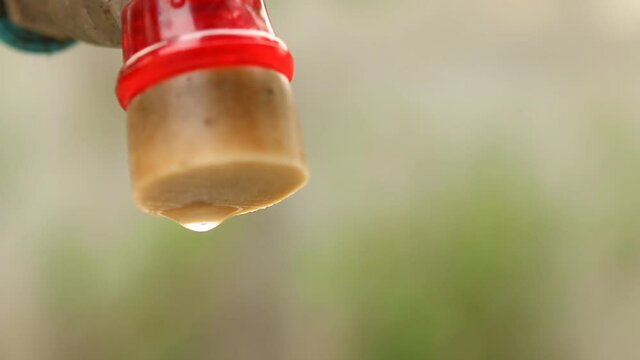 Water dropping from tap water  , climate change or lack of water concept  .