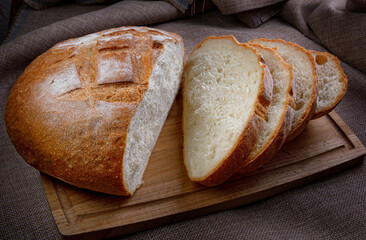 White village bread on a wooden cutting board.