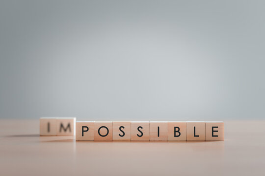 Text "POSSIBLE" on wooden block, Making possible is possible by leaving the impossible behind, Business, success, challenge, motivation, action and reaching goals, achievement and possible concept.