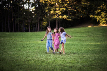  Three little girls together in nature. Walking and talking.