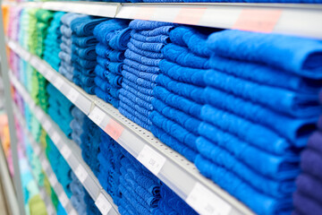 Blue cotton towels on the shelves in the supermarket.