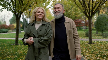 Beautiful family couple observing autumn nature in daytime. Close up of people.