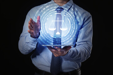 Male lawyer with tablet computer using virtual screen on dark background