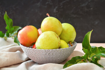 Bowl with tasty apple and pear fruits on table