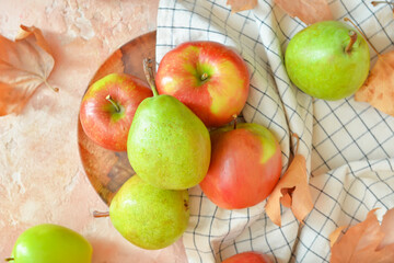 Plate with tasty apple and pear fruits on color background