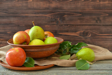 Bowl with tasty apple and pear fruits on table