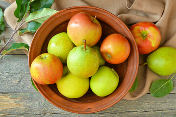 Naklejka na ściany i meble Bowl with tasty apple and pear fruits on table