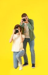 Young photographers on color background